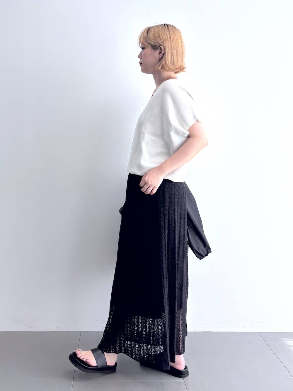 ホワイト系のニット/セーター、ブラック系のブルゾン、ブラック系のスカートを着用したレディースの夏コーディネートの6枚目の写真