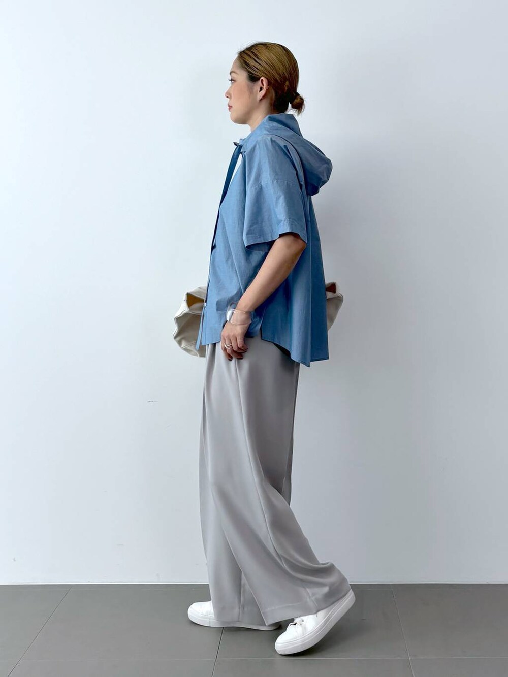 ブラック系のTシャツ/カットソー、ホワイト系のトートバッグ、ホワイト系のスニーカーを着用したレディースの夏コーディネートの3枚目の写真