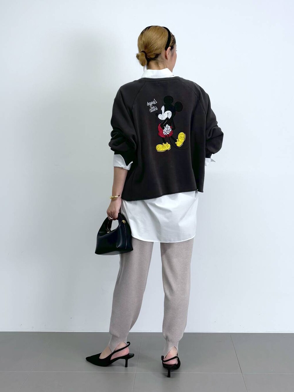 ブラック系のショルダーバッグ、ホワイト系のシャツ/ブラウス、ブラック系のパンプスを着用したレディースの秋コーディネートの3枚目の写真