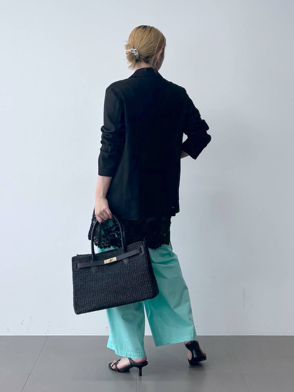 ブルー系のその他パンツ、ブラック系のテーラードジャケット、ブラック系のかごバッグを着用したレディースの春コーディネートの4枚目の写真