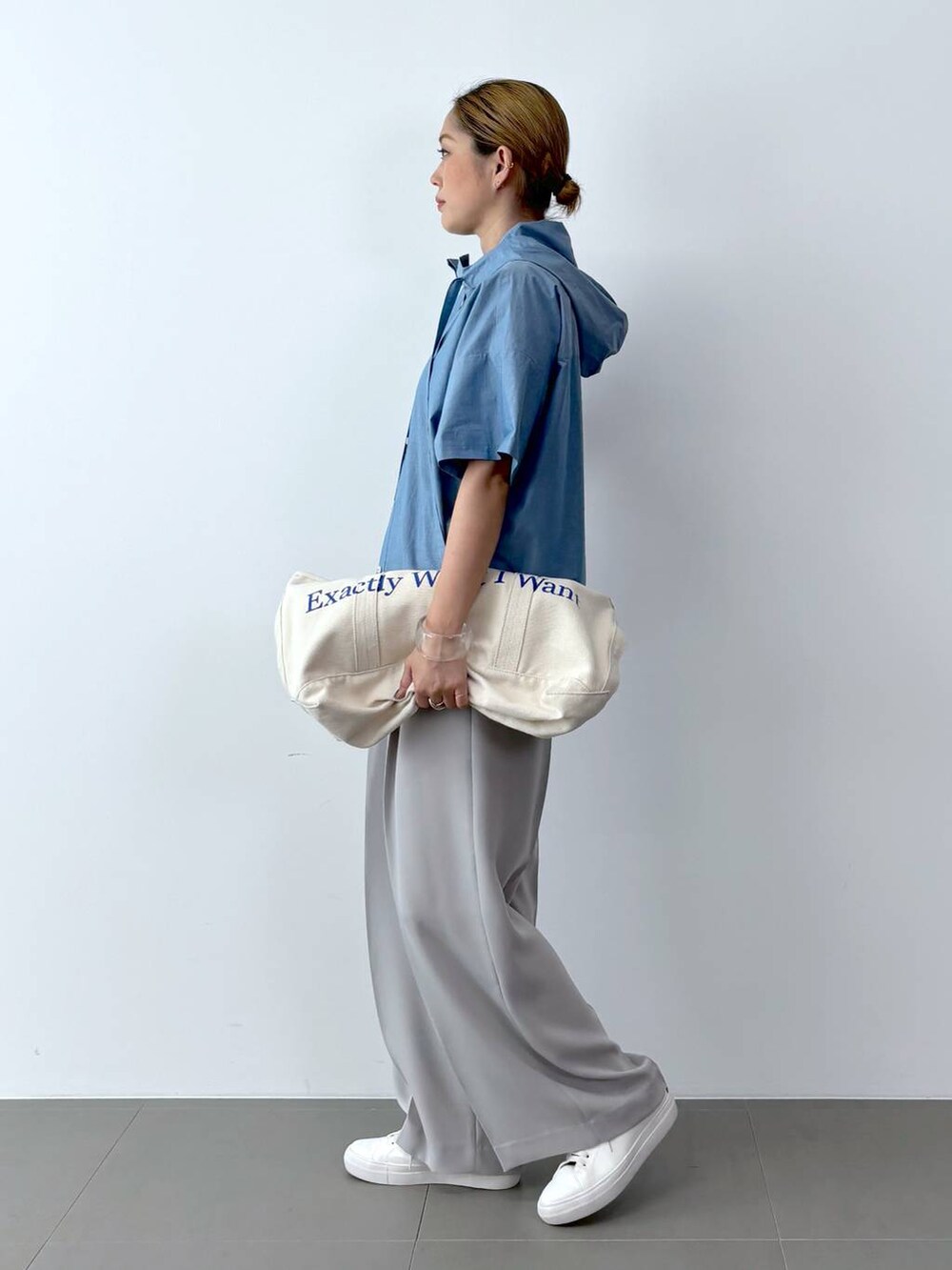 ブラック系のTシャツ/カットソー、ホワイト系のトートバッグ、ホワイト系のスニーカーを着用したレディースの夏コーディネートの2枚目の写真