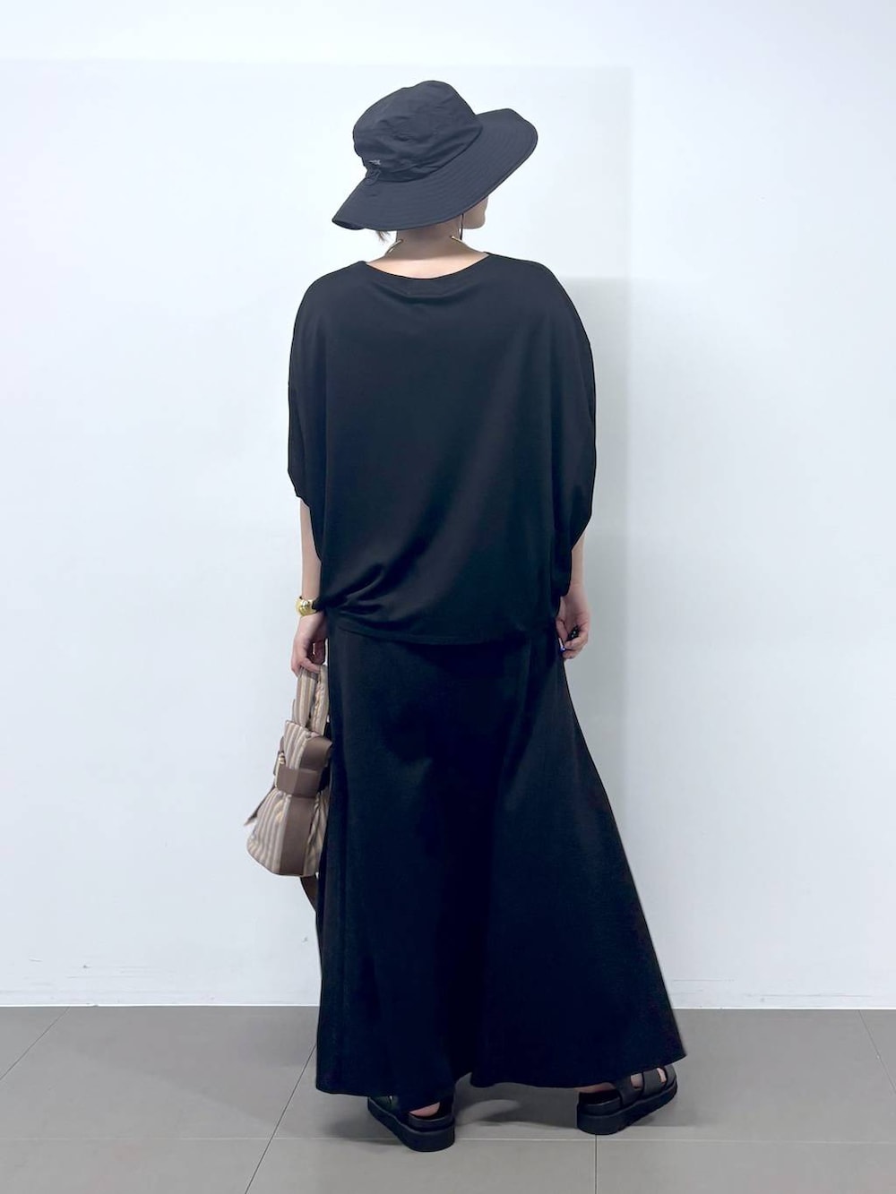 ブラック系のTシャツ/カットソー、ベージュ系のショルダーバッグ、ブラック系のスカートを着用したレディースの春コーディネートの3枚目の写真