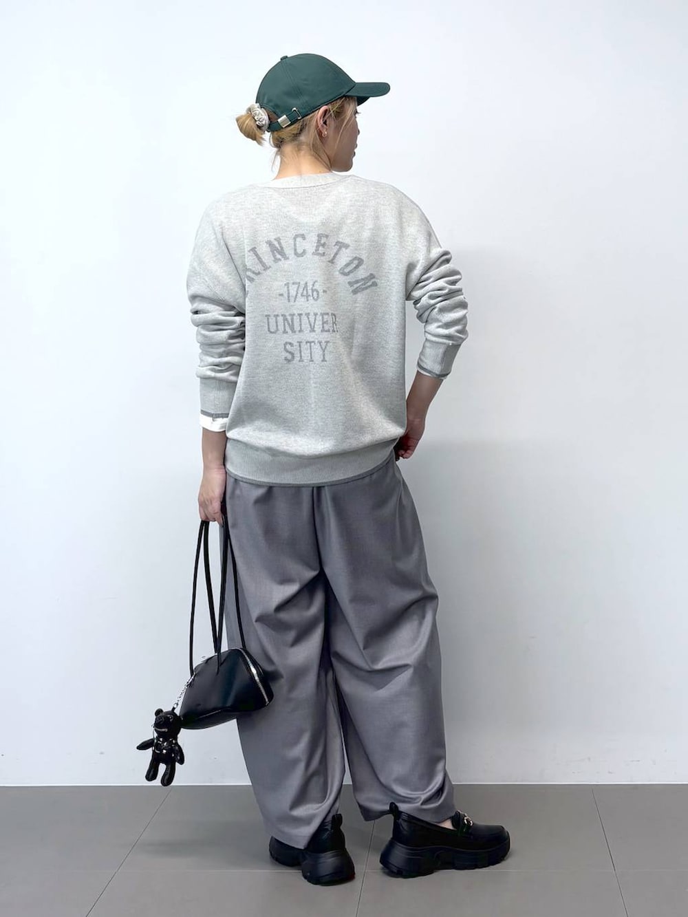 ホワイト系のTシャツ/カットソー、グレー系のその他パンツ、ブラック系のハンドバッグを着用したレディースの春コーディネートの4枚目の写真