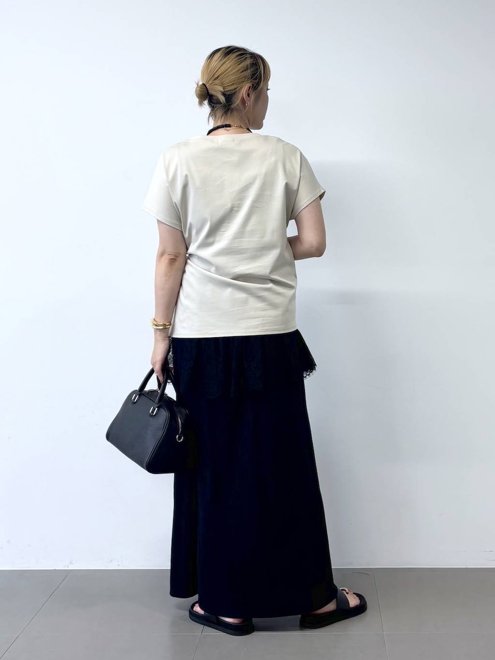 グレー系のTシャツ/カットソー、ブラック系のボストンバッグ、ブラック系のサンダルを着用したレディースの夏コーディネートの5枚目の写真