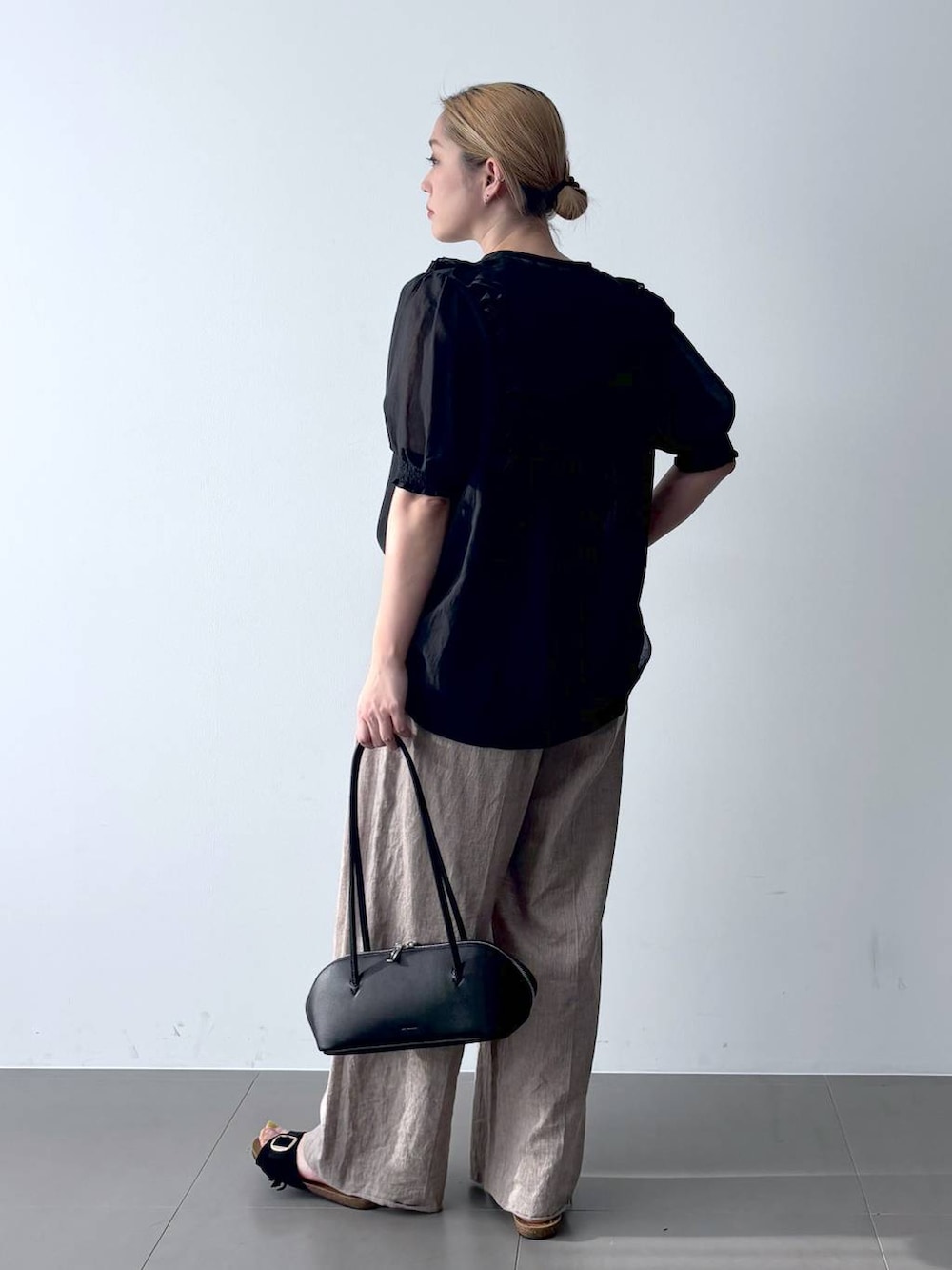 ベージュ系のその他パンツ、ブラック系のシャツ/ブラウス、ブラック系のハンドバッグを着用したレディースの春コーディネートの5枚目の写真