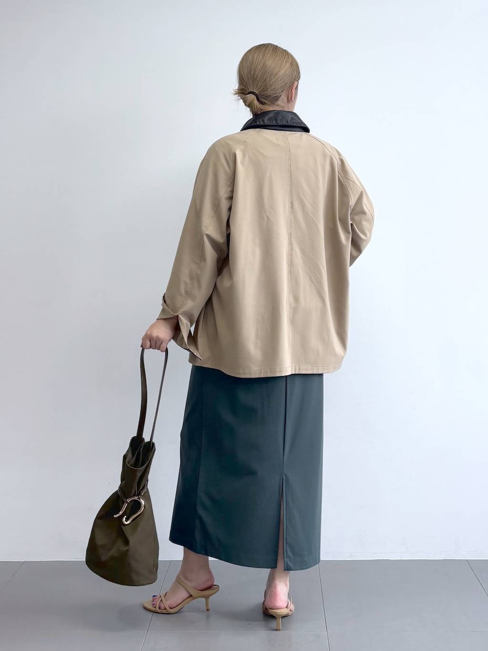 ホワイト系のTシャツ/カットソー、グリーン系のスカート、ベージュ系のカバーオールを着用したレディースの冬コーディネートの4枚目の写真