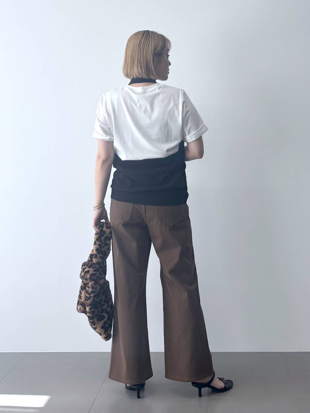 ホワイト系のTシャツ/カットソー、ブラック系のサンダル、ブラック系のベストを着用したレディースの夏コーディネートの7枚目の写真