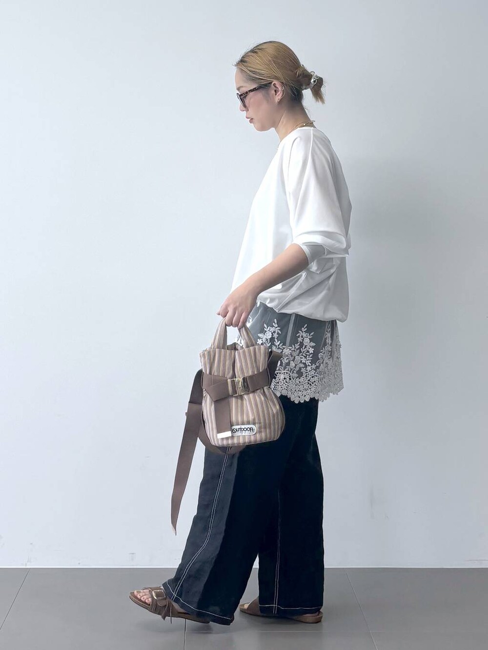 ホワイト系のTシャツ/カットソー、ベージュ系のショルダーバッグ、ブルー系のその他パンツを着用したレディースの春コーディネートの2枚目の写真