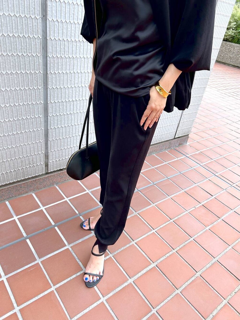 ブラック系のトートバッグ、ブラック系のブルゾン、ブラック系のサンダルを着用したレディースの秋コーディネートの7枚目の写真