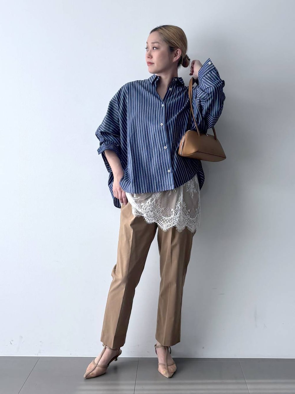 ブルー系のシャツ/ブラウス、ブラウン系のハンドバッグ、ベージュ系のその他パンツを着用したレディースの春コーディネートの2枚目の写真
