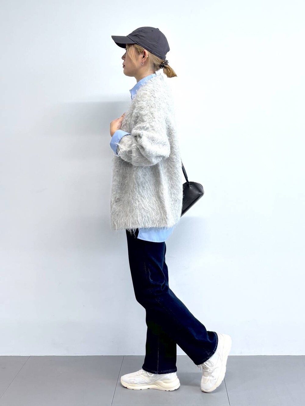 ブラック系のショルダーバッグ、ブルー系のシャツ/ブラウス、ブルー系のデニムパンツを着用したレディースの秋コーディネートの3枚目の写真