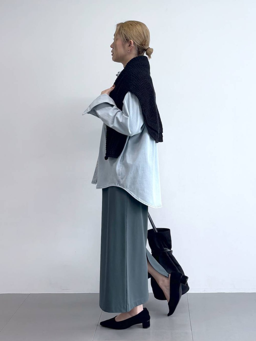 ブルー系のシャツ/ブラウス、ブラック系のニット/セーター、ブラック系のパンプスを着用したレディースの冬コーディネートの3枚目の写真