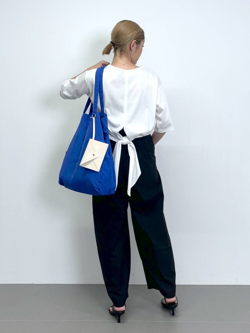 ブラック系のスリッポン、ブラック系のその他パンツ、ホワイト系のTシャツ/カットソーを着用したレディースの夏コーディネートの4枚目の写真