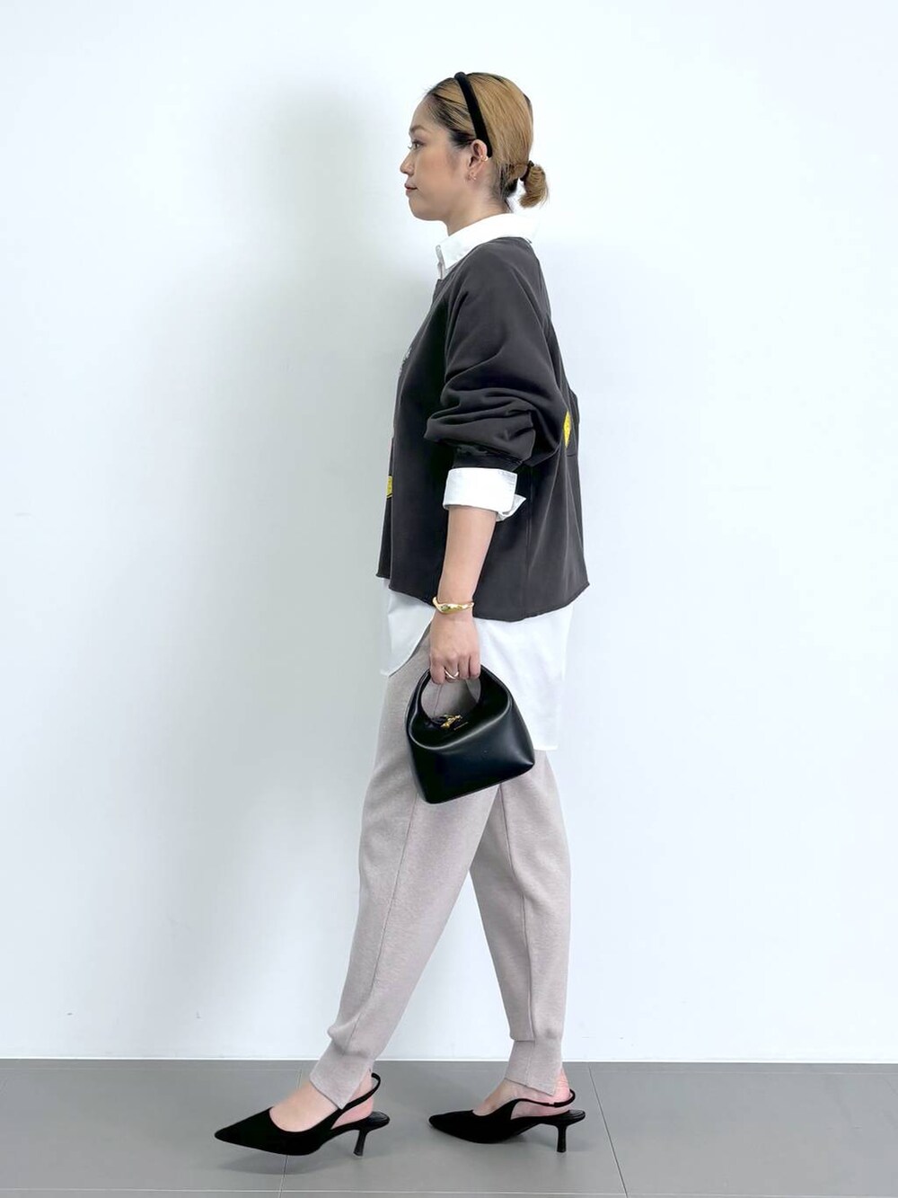 ブラック系のショルダーバッグ、ホワイト系のシャツ/ブラウス、ブラック系のパンプスを着用したレディースの秋コーディネートの2枚目の写真