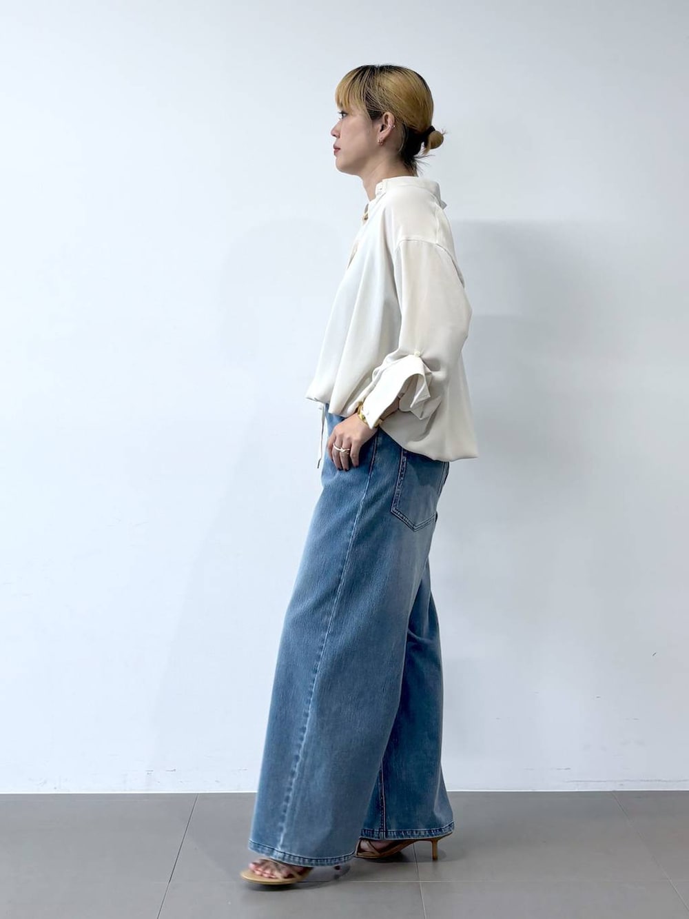 ブルー系のデニムパンツ、ベージュ系のサンダル、ホワイト系のシャツ/ブラウスを着用したレディースの夏コーディネートの5枚目の写真