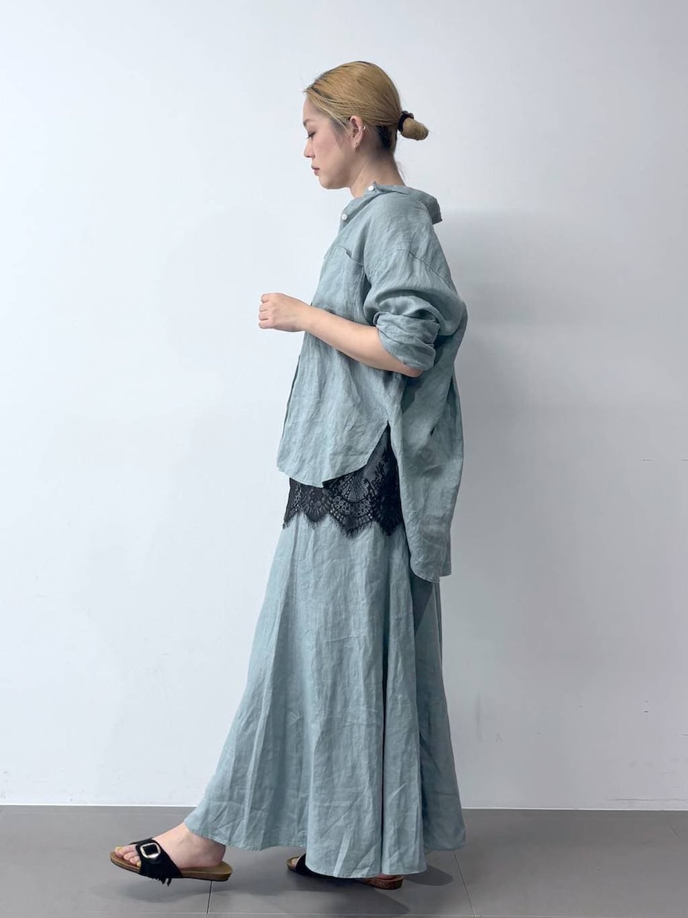 グリーン系のシャツ/ブラウス、グリーン系のスカート、ブラック系のショルダーバッグを着用したレディースの春コーディネートの3枚目の写真