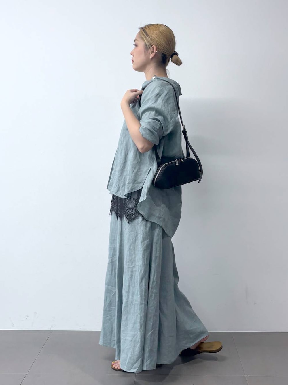 グリーン系のシャツ/ブラウス、グリーン系のスカート、ブラック系のショルダーバッグを着用したレディースの春コーディネートの2枚目の写真