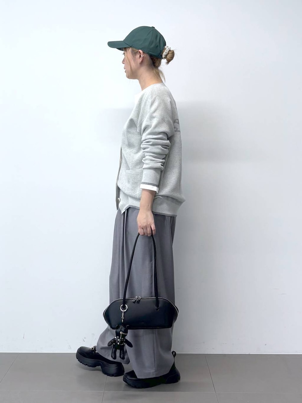 ホワイト系のTシャツ/カットソー、グレー系のその他パンツ、ブラック系のハンドバッグを着用したレディースの春コーディネートの2枚目の写真