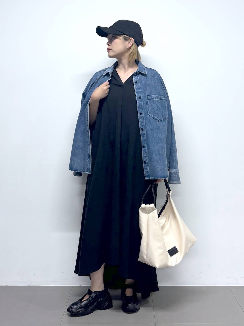 ブルー系のシャツ/ブラウス、ブラック系のワンピース、ホワイト系のトートバッグを着用したレディースの夏コーディネートの2枚目の写真