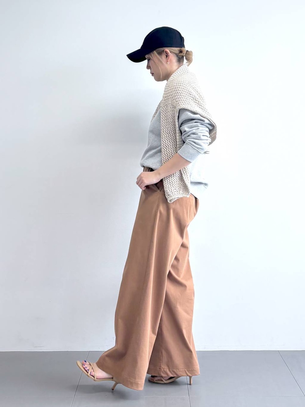 ベージュ系のニット/セーター、グレー系のスウェット、イエロー系のその他パンツを着用したレディースの冬コーディネートの3枚目の写真