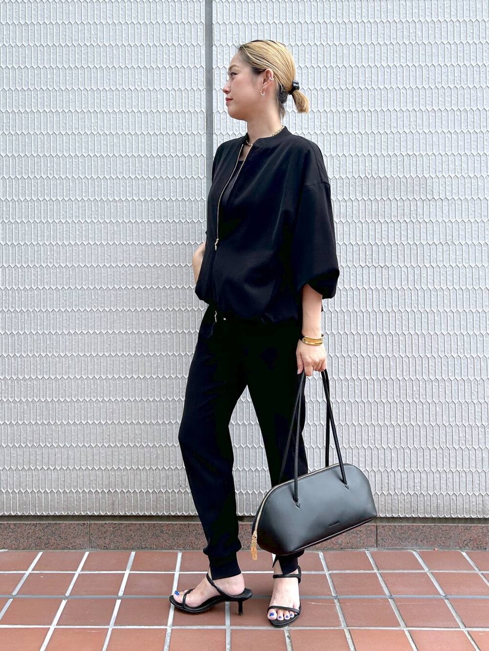 ブラック系のトートバッグ、ブラック系のブルゾン、ブラック系のサンダルを着用したレディースの秋コーディネートの3枚目の写真