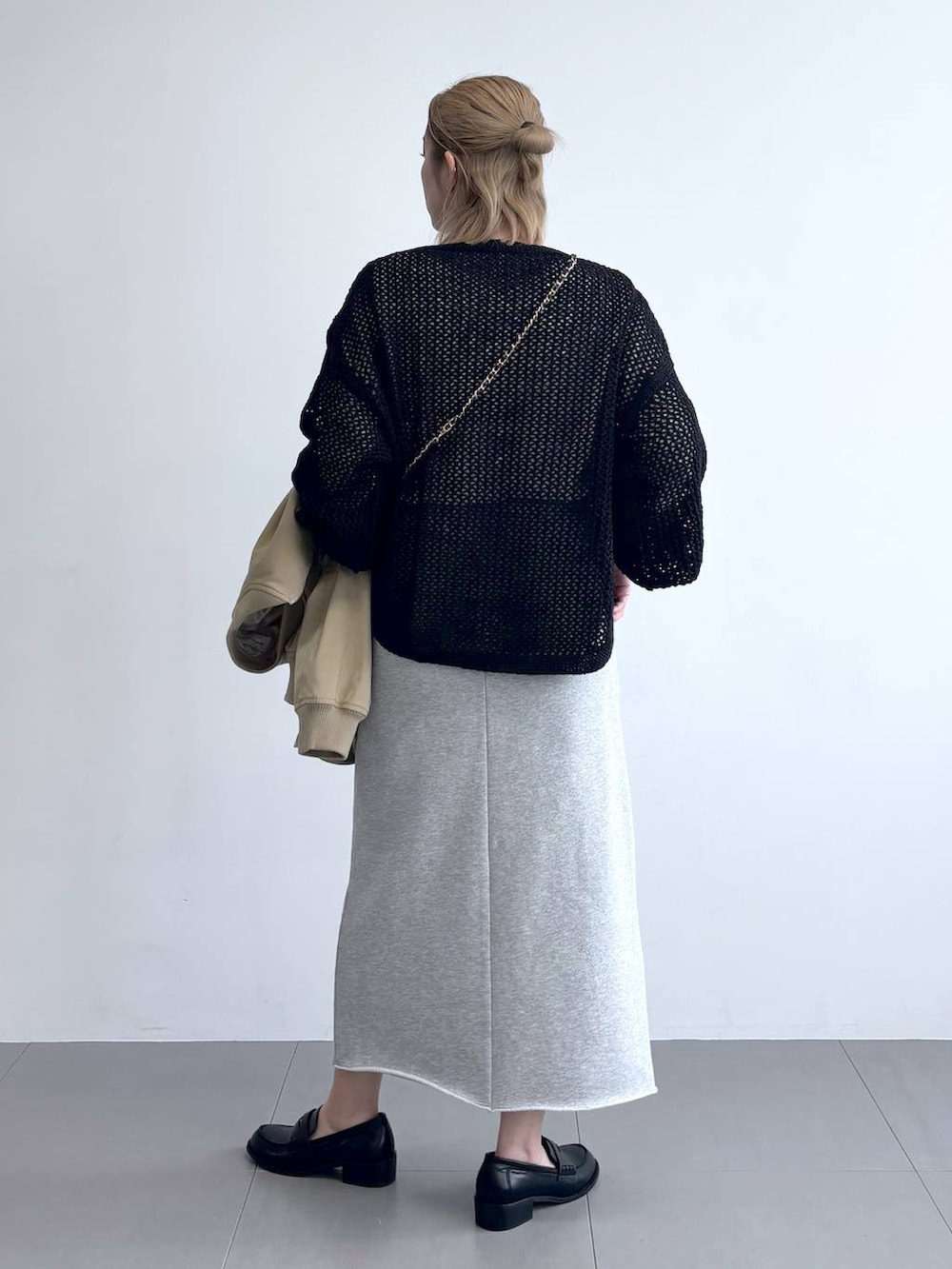 ブラック系のニット/セーター、ベージュ系のMA-1、グレー系のスカートを着用したレディースの冬コーディネートの6枚目の写真