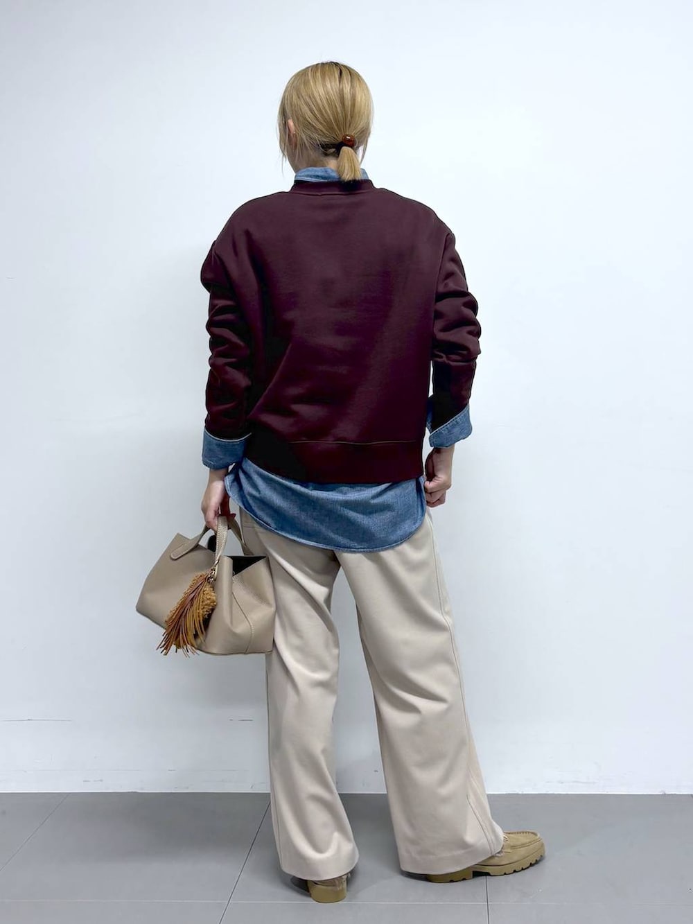 ベージュ系のローファー、レッド系のスウェット、ベージュ系のその他パンツを着用したレディースの秋コーディネートの4枚目の写真