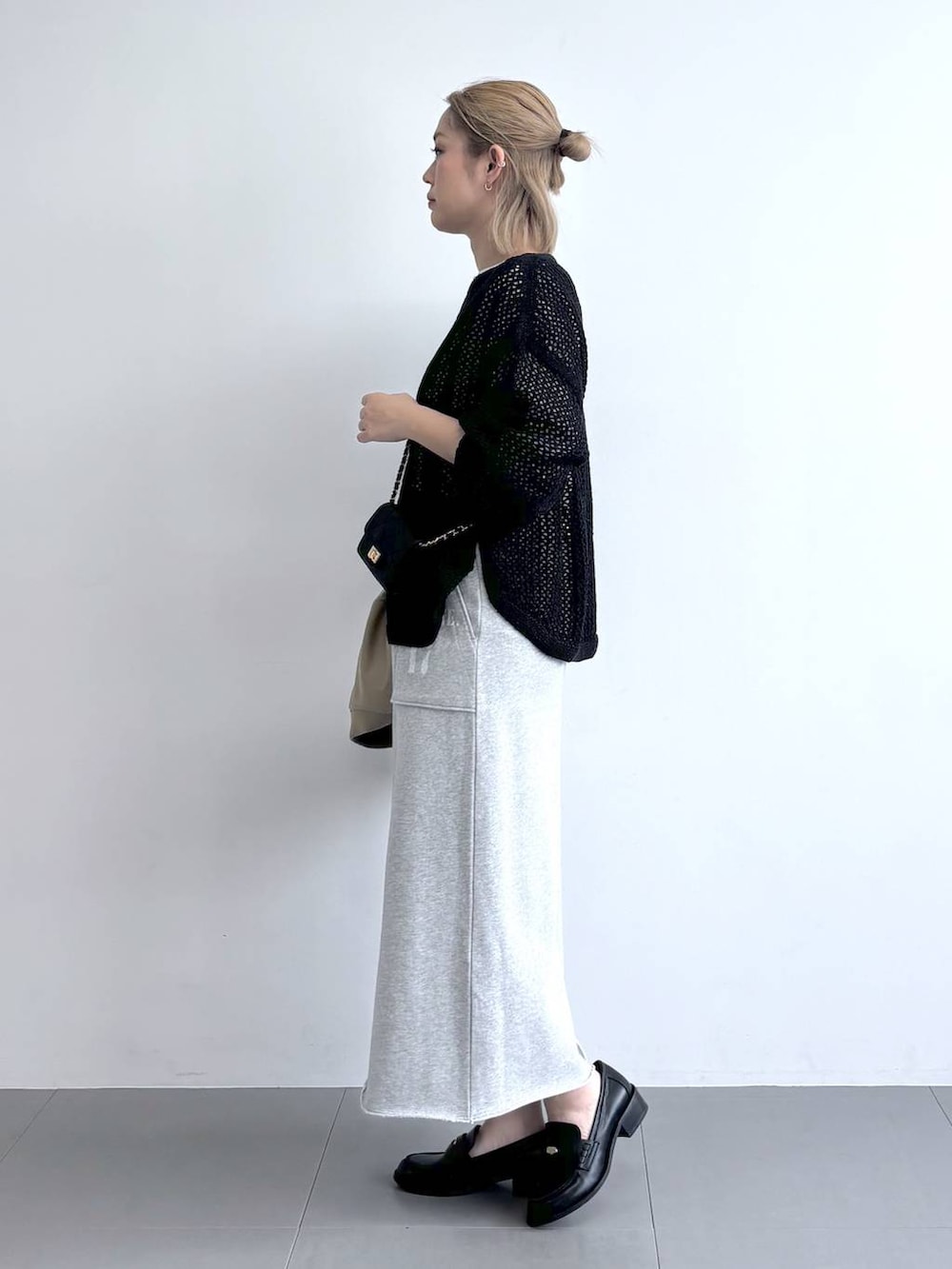 ブラック系のニット/セーター、ベージュ系のMA-1、グレー系のスカートを着用したレディースの冬コーディネートの5枚目の写真