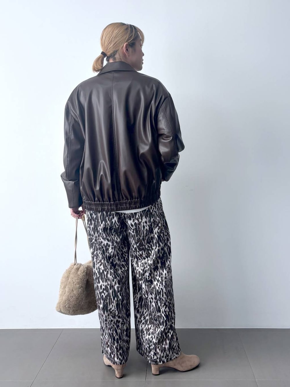 ベージュ系のその他パンツ、ブラウン系のブルゾン、ホワイト系のTシャツ/カットソーを着用したレディースの秋コーディネートの4枚目の写真