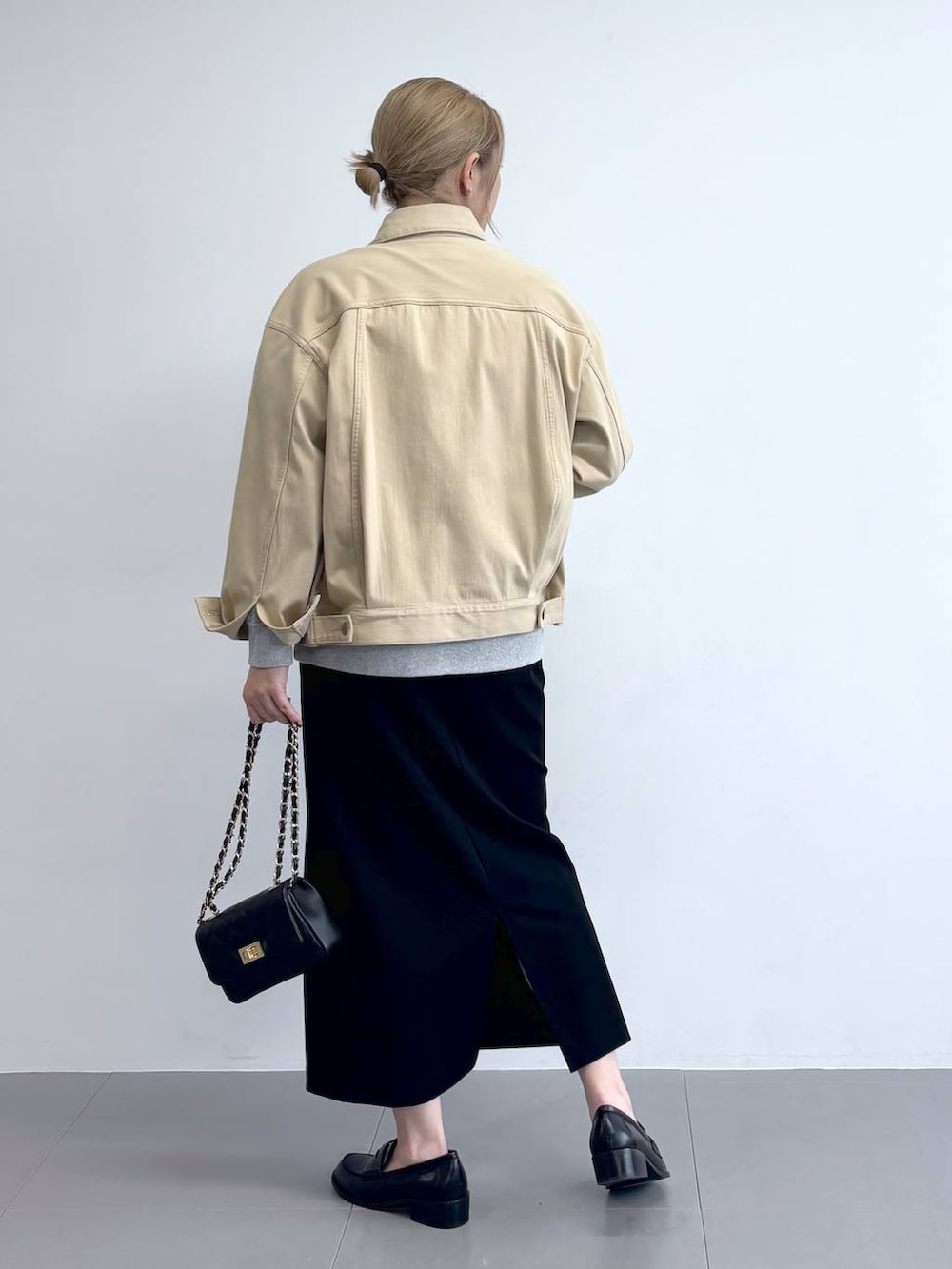 ベージュ系のデニムジャケット、グレー系のスウェット、ブラック系のスカートを着用したレディースの冬コーディネートの5枚目の写真