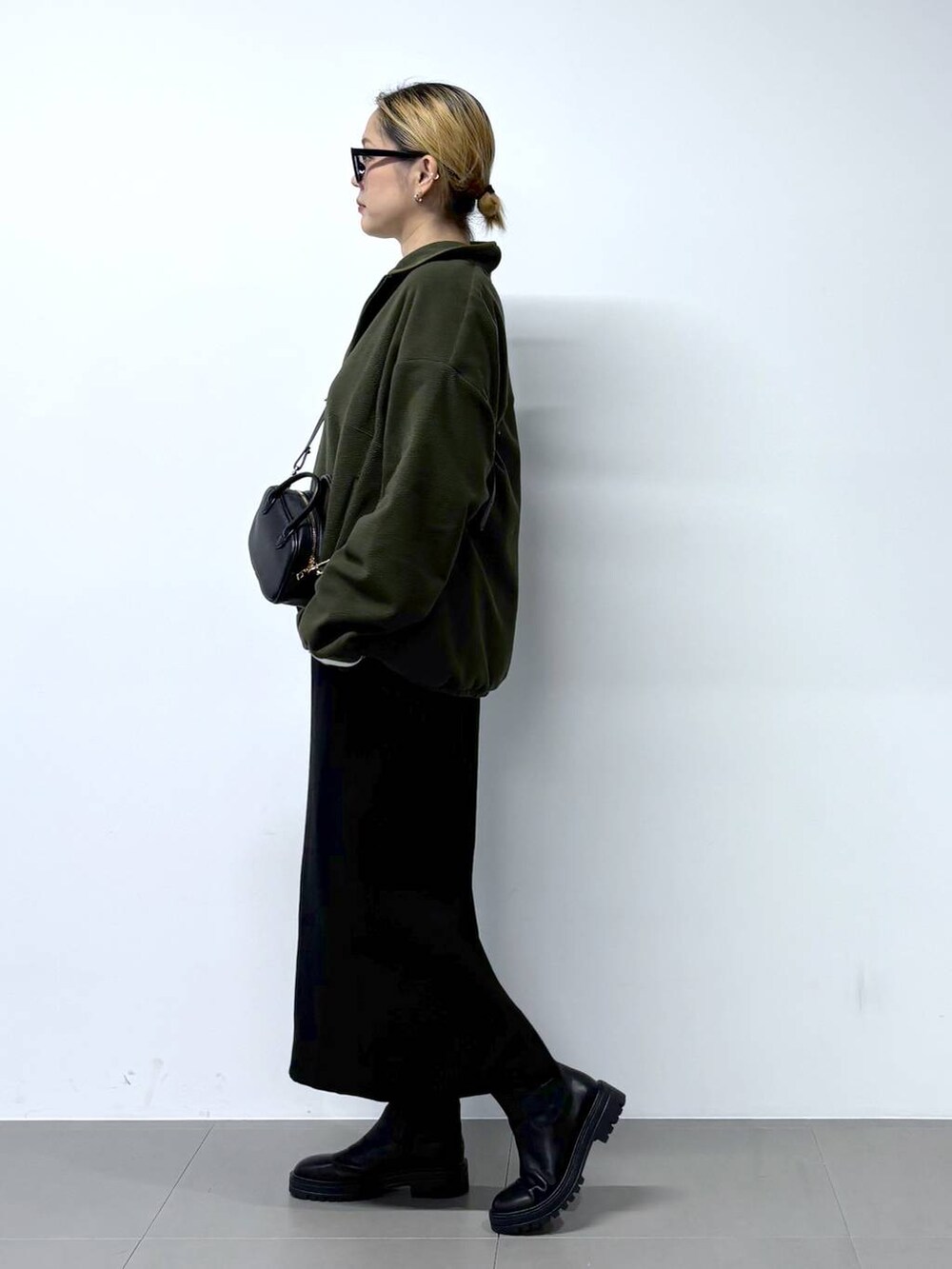 ブラック系のブーツ、ホワイト系のTシャツ/カットソー、ブラック系のショルダーバッグを着用したレディースの秋コーディネートの3枚目の写真