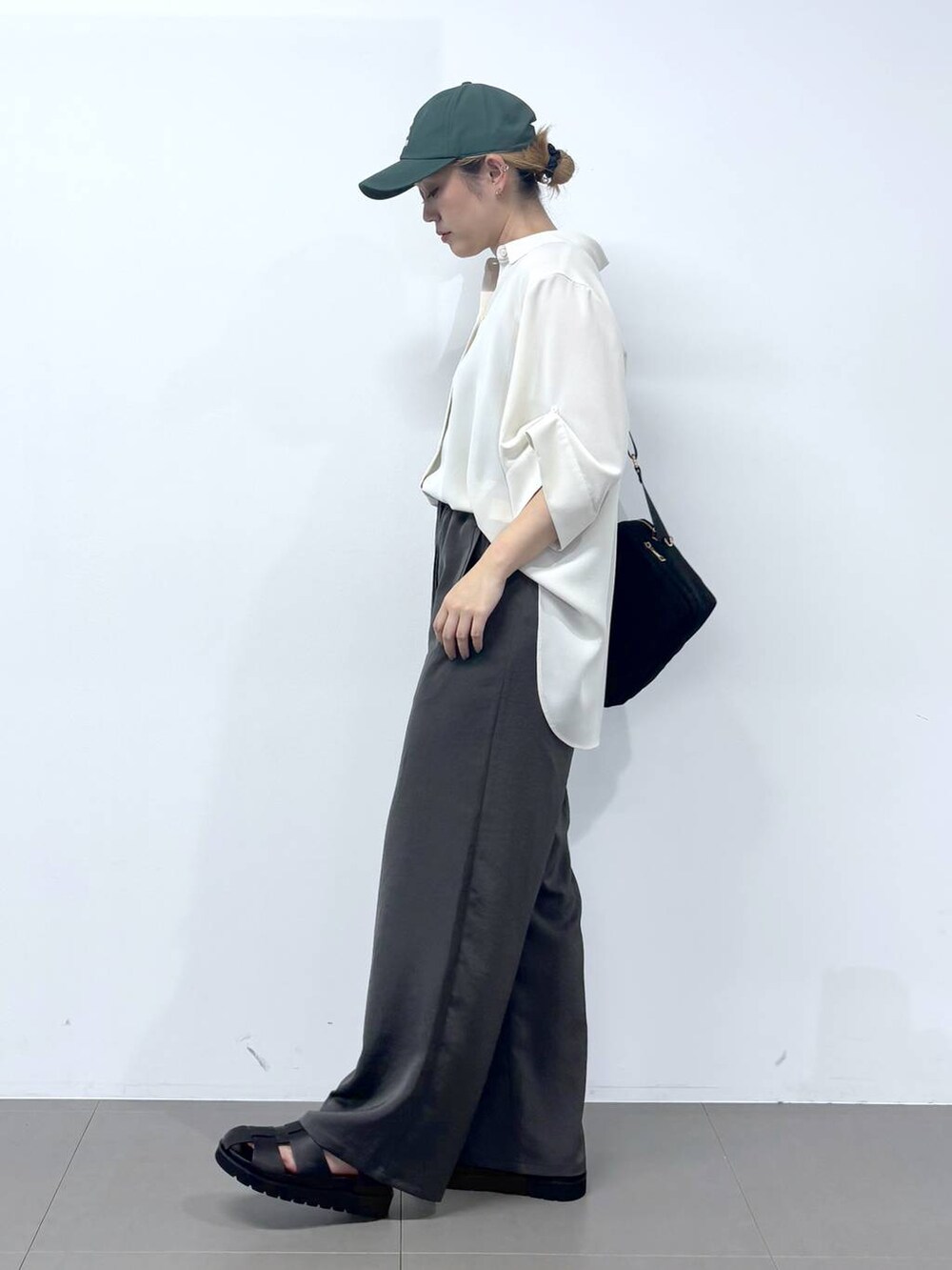 グレー系のその他パンツ、ホワイト系のシャツ/ブラウス、ブラック系のサンダルを着用したレディースの春コーディネートの3枚目の写真