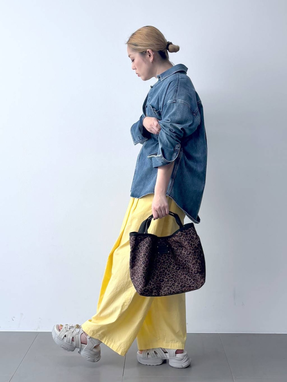イエロー系のその他パンツ、ブルー系のシャツ/ブラウス、その他のトートバッグを着用したレディースの春コーディネートの3枚目の写真