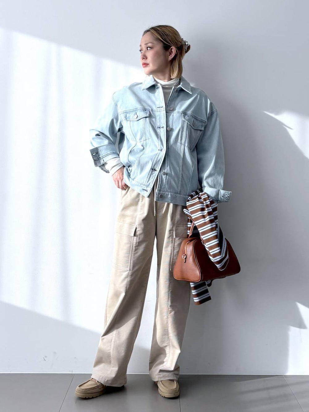 イエロー系のボストンバッグ、ホワイト系のTシャツ/カットソー、ベージュ系のローファーを着用したレディースの冬コーディネートの4枚目の写真