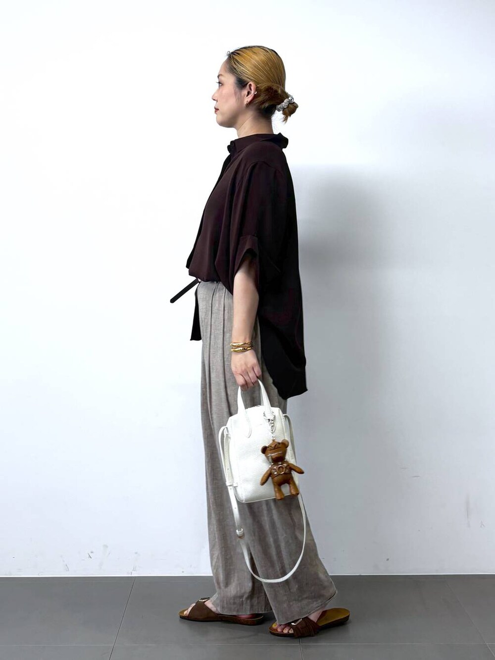 ベージュ系のその他パンツ、ブラウン系のシャツ/ブラウス、ホワイト系のショルダーバッグを着用したレディースの春コーディネートの3枚目の写真