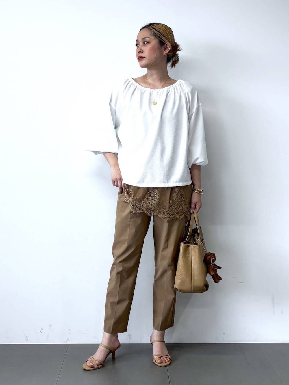 ホワイト系のシャツ/ブラウス、ベージュ系のその他パンツ、イエロー系のトートバッグを着用したレディースの春コーディネートの2枚目の写真