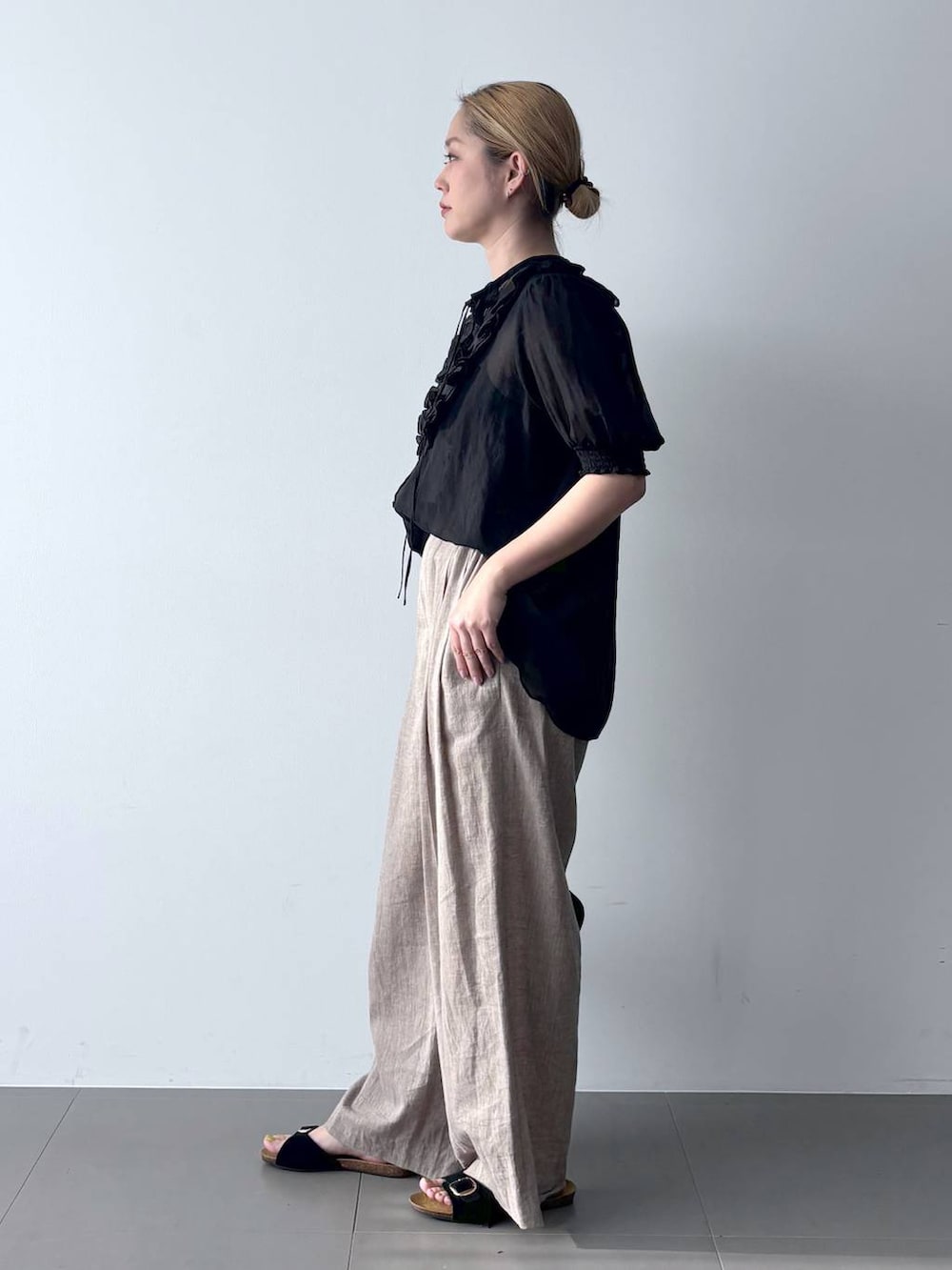 ベージュ系のその他パンツ、ブラック系のシャツ/ブラウス、ブラック系のハンドバッグを着用したレディースの春コーディネートの3枚目の写真