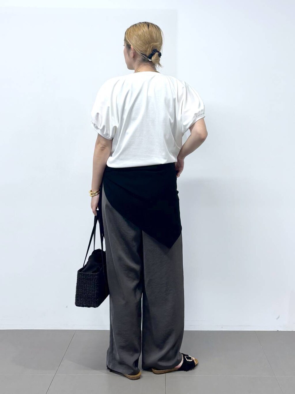 グレー系のその他パンツ、ホワイト系のTシャツ/カットソー、ブラック系のサンダルを着用したレディースの春コーディネートの2枚目の写真