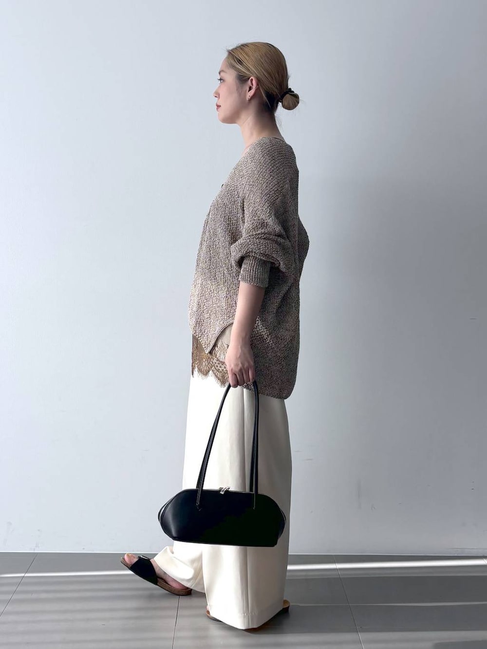 ブラウン系のカーディガン/ボレロ、ブラック系のハンドバッグ、ホワイト系のその他パンツを着用したレディースの春コーディネートの3枚目の写真