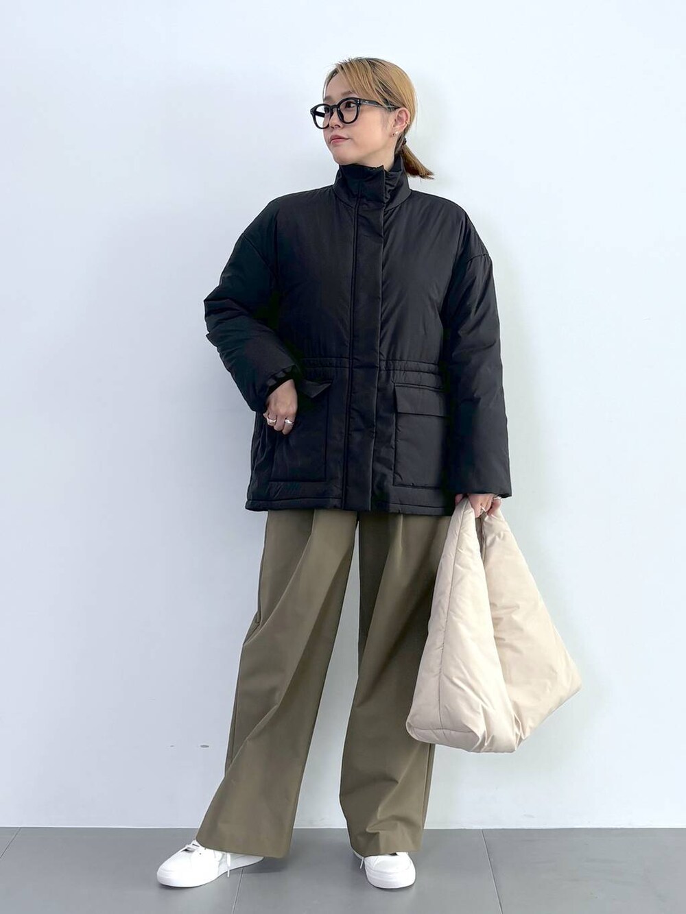 ブラック系のブルゾン、ホワイト系のスニーカー、グレー系のニット/セーターを着用したレディースの秋コーディネートの2枚目の写真