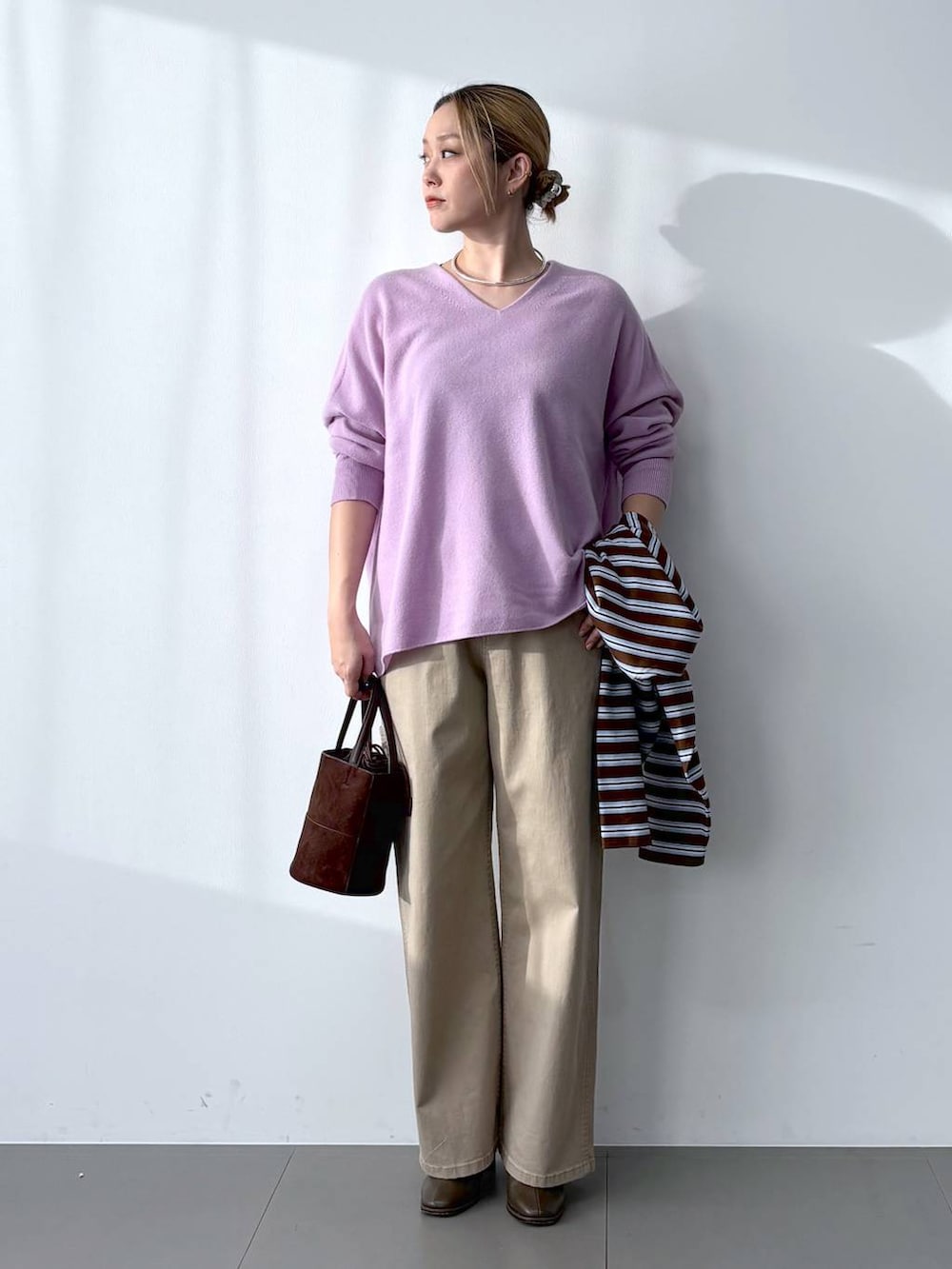 ブラウン系のブーツ、パープル系のニット/セーター、ブラウン系のTシャツ/カットソーを着用したレディースの冬コーディネートの4枚目の写真