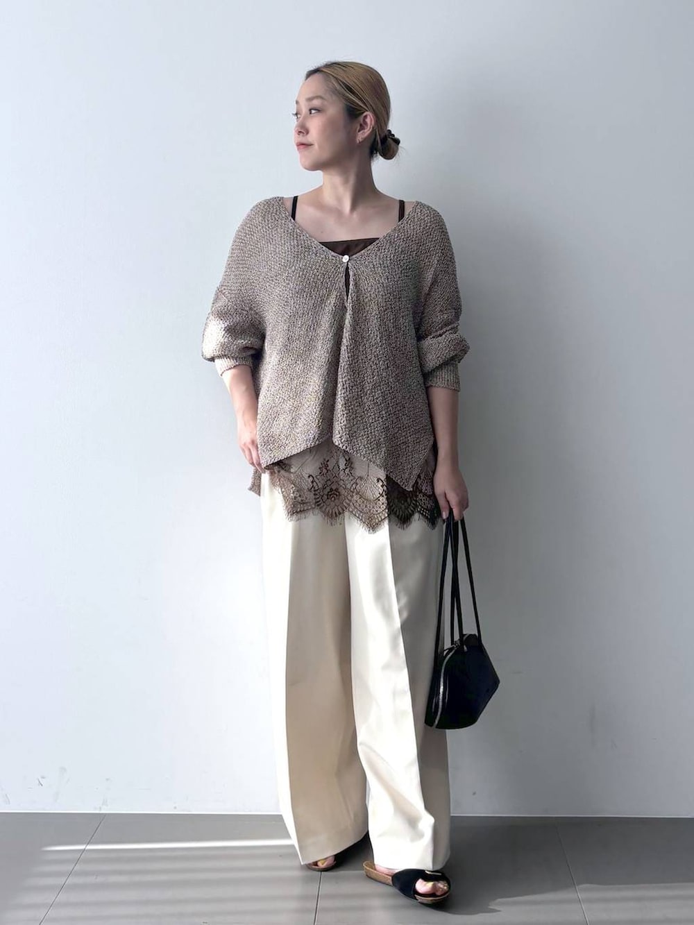 ブラウン系のカーディガン/ボレロ、ブラック系のハンドバッグ、ホワイト系のその他パンツを着用したレディースの春コーディネートの2枚目の写真