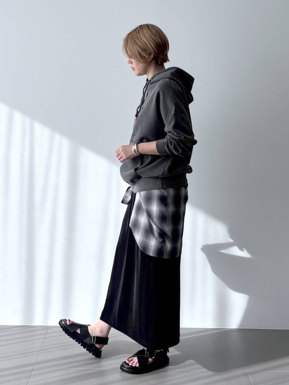 シルバー系のハンドバッグ、グレー系のシャツ/ブラウス、ブラック系のスカートを着用したレディースの春コーディネートの3枚目の写真