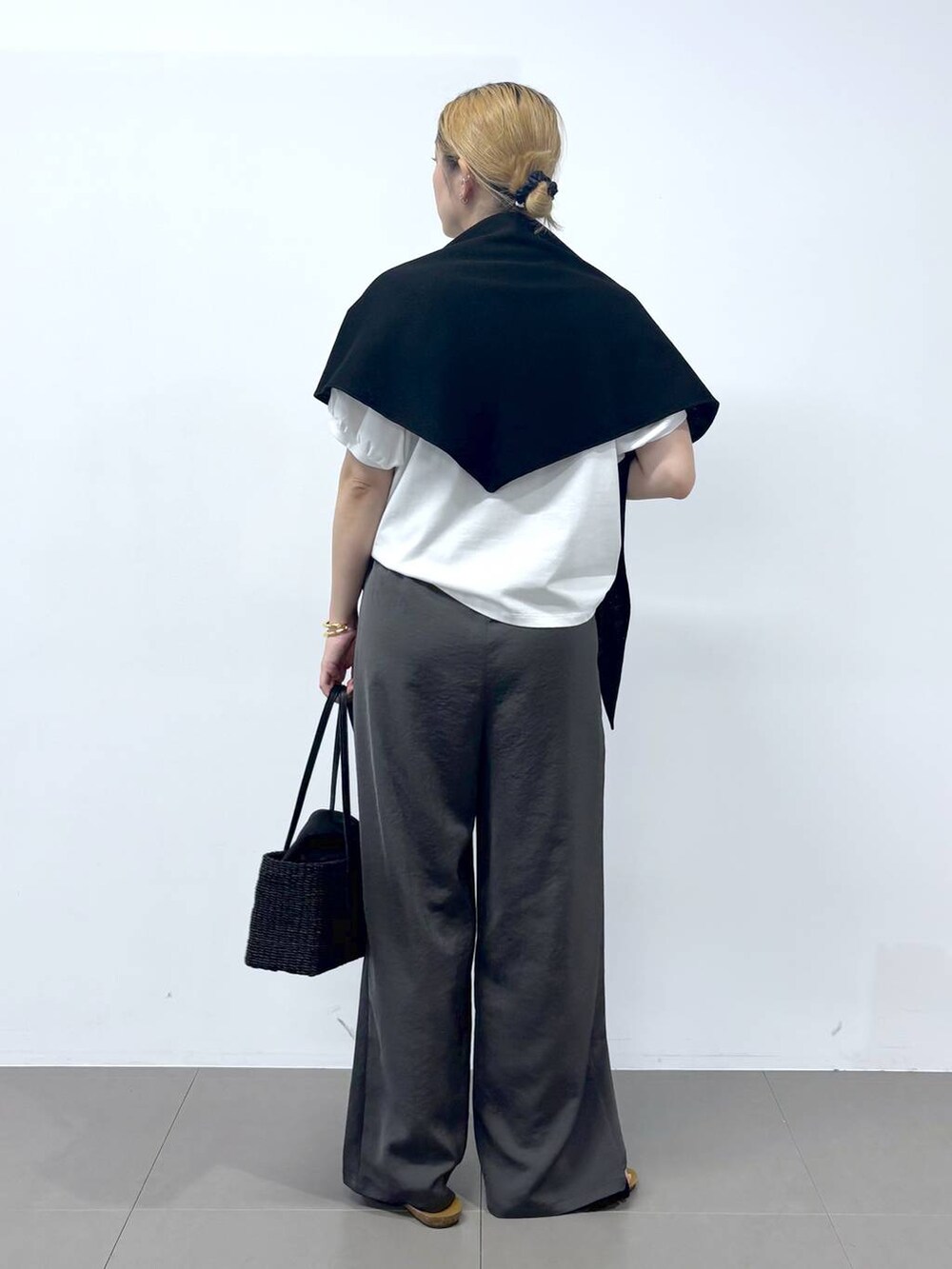 グレー系のその他パンツ、ホワイト系のTシャツ/カットソー、ブラック系のサンダルを着用したレディースの春コーディネートの4枚目の写真