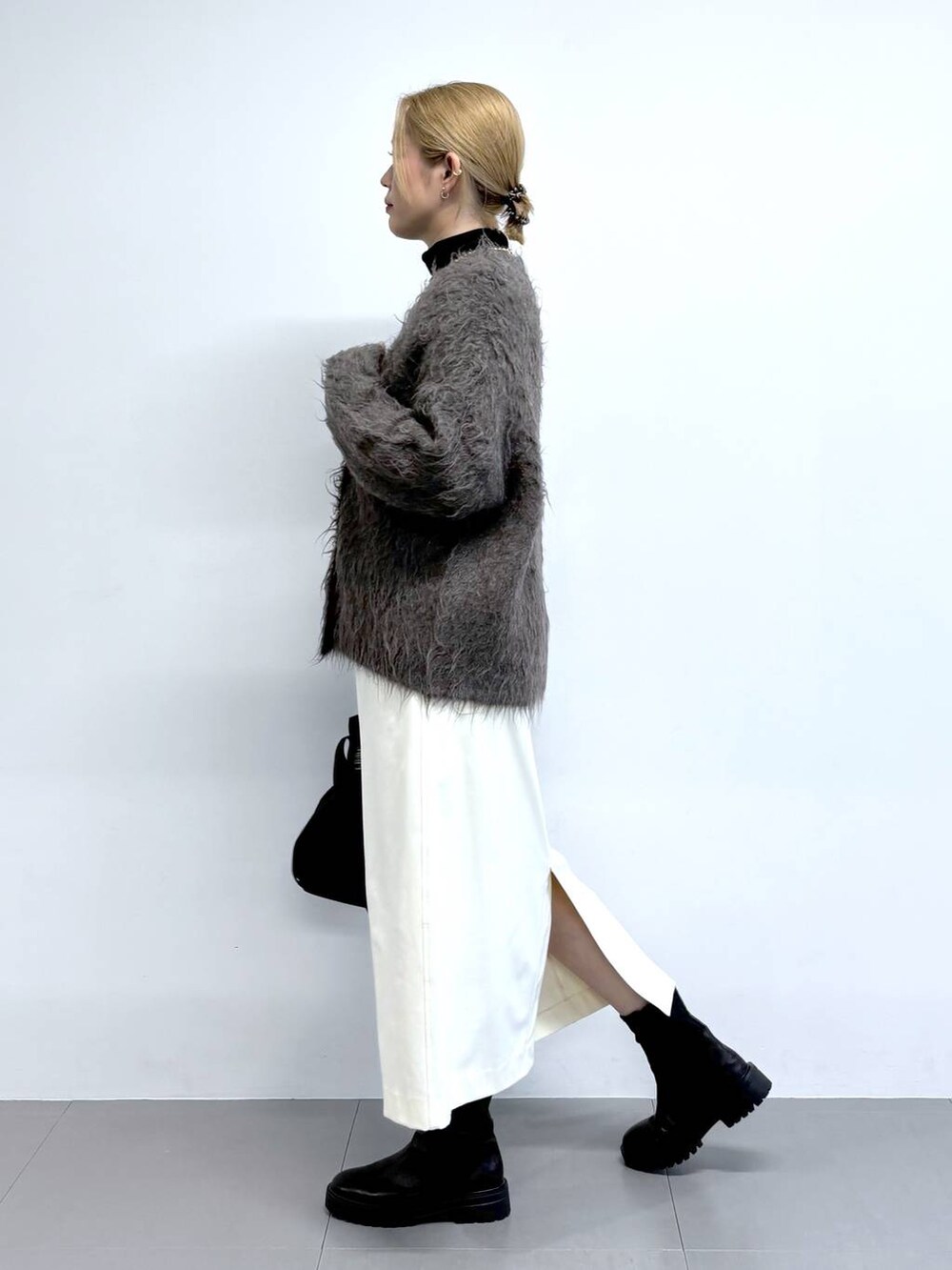 ブラック系のブーツ、ブラウン系のカーディガン/ボレロ、その他のショルダーバッグを着用したレディースの秋コーディネートの3枚目の写真