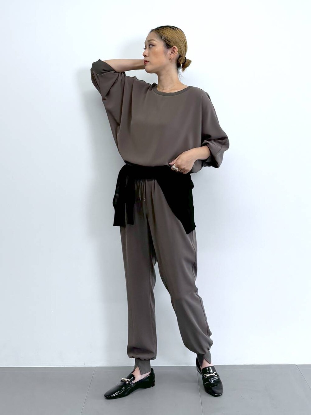 ブラック系のレインシューズ、グレー系のトートバッグ、ブラウン系のその他パンツを着用したレディースの夏コーディネートの3枚目の写真