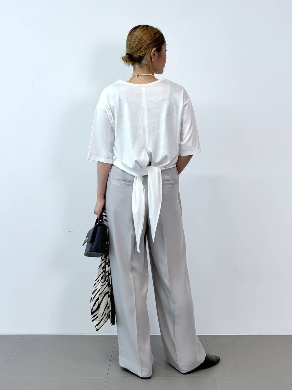 ブルー系のショルダーバッグ、ブラック系のレインシューズ、ホワイト系のトートバッグを着用したレディースの夏コーディネートの4枚目の写真