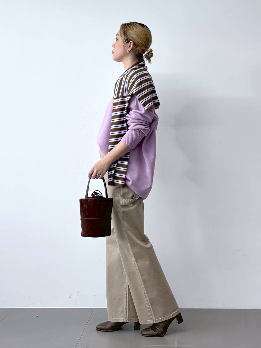 ブラウン系のブーツ、パープル系のニット/セーター、ブラウン系のTシャツ/カットソーを着用したレディースの冬コーディネートの2枚目の写真