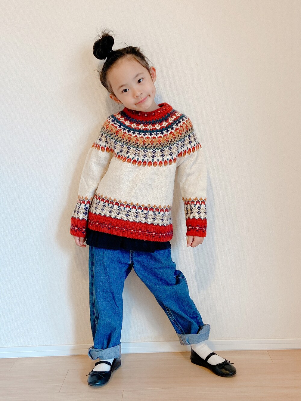 ブルー系のデニムパンツ、レッド系のニット/セーター、ブラック系のバレエシューズを着用したキッズの冬コーディネートの2枚目の写真