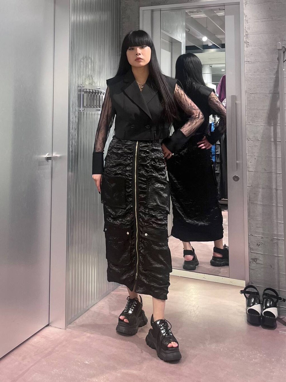 ブラック系のサンダル、ブラック系のテーラードジャケット、ブラック系のスカートを着用したレディースの夏コーディネートの2枚目の写真